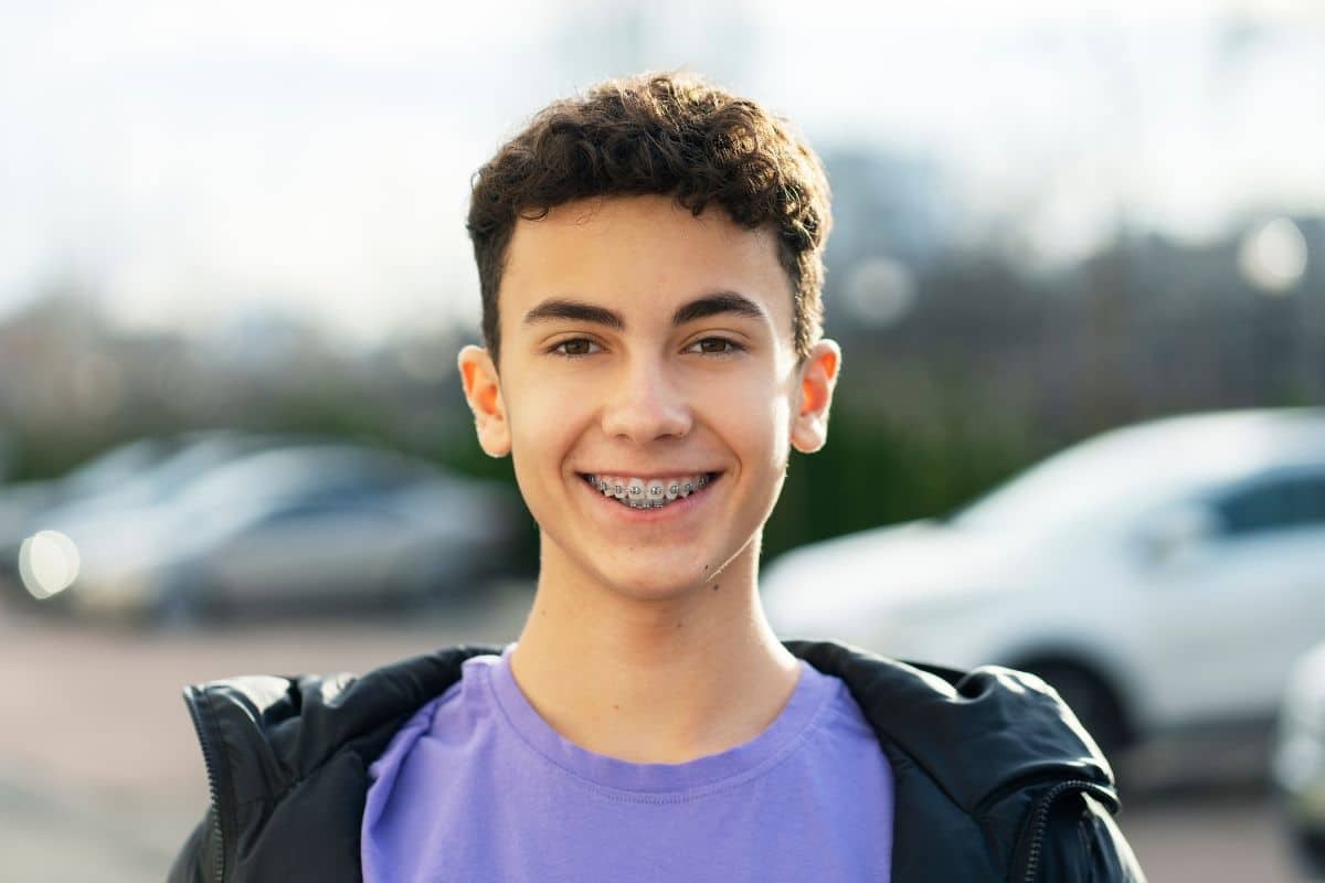 A teen is smiling with braces.