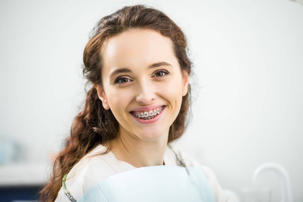 Young woman smiling with braces at a dental office.