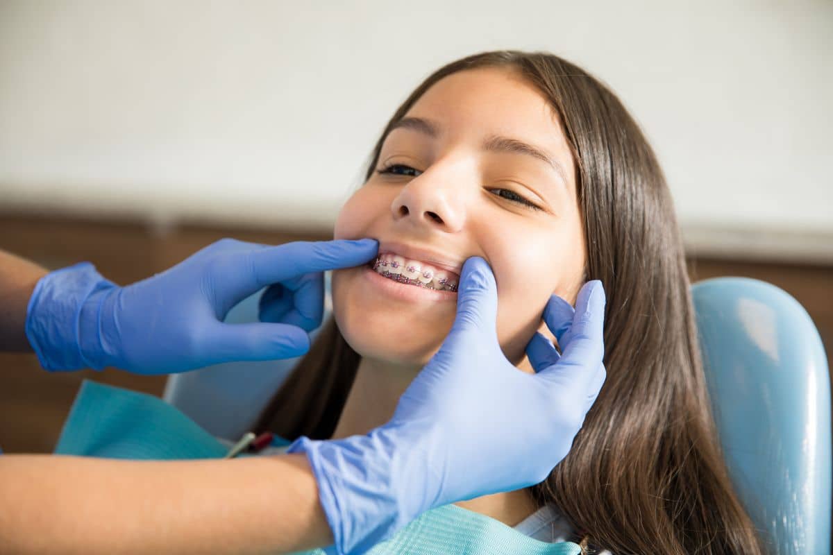Orthodontist adjusting a young patient’s braces during treatment.